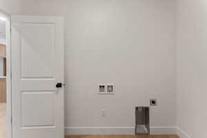 Washroom featuring light wood-type flooring, hookup for a washing machine, and electric dryer hookup