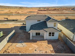 View of front facade featuring a fenced backyard, a tile roof, stucco siding, and a patio area