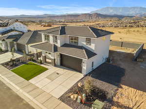 View of front of home with driveway, stucco siding, a mountain view, and a tiled roof