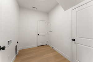 Washroom featuring light wood-style floors, hookup for an electric dryer, and washer hookup
