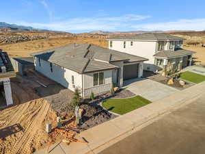 View of front facade featuring a mountain view, stucco siding, driveway, and a tile roof