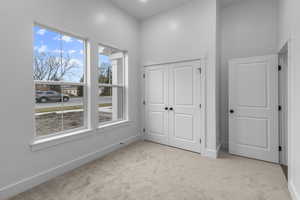 Unfurnished bedroom featuring light colored carpet and a closet