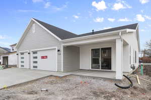 View of front of property with concrete driveway, a garage, and a shingled roof