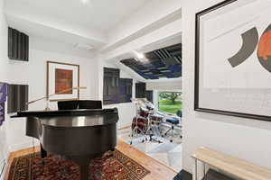 Office space with vaulted ceiling, light wood-style floors, and a baseboard radiator