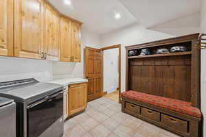 Laundry area with washing machine and dryer, cabinet space, recessed lighting, and light tile patterned floors