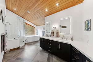 Full bathroom with a soaking tub, a marble finish shower, double vanity, lofted ceiling, and recessed lighting