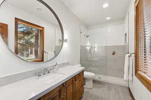 Bathroom featuring vanity, walk in shower, recessed lighting, and light tile patterned flooring