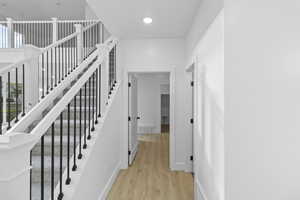 Staircase featuring wood finished floors and recessed lighting