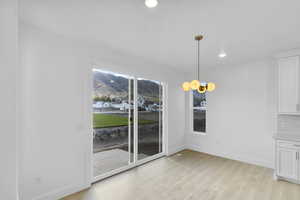 Dining area featuring light wood-style floors, recessed lighting, and a mountain view