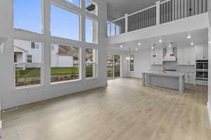 Living room featuring a towering ceiling and light wood-type flooring