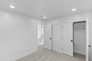 Bedroom 2 featuring light colored carpet, a closet, and recessed lighting