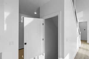 Corridor with light wood-type flooring and recessed lighting