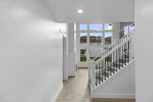 Stairway featuring wood finished floors and recessed lighting
