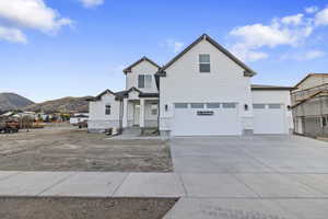 View of front of house featuring stone siding, concrete driveway, and a mountain view