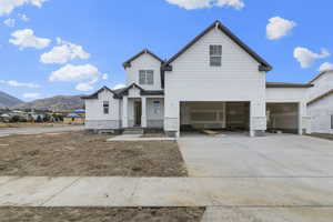 View of front facade featuring a mountain view, driveway, stone siding, and an attached garage