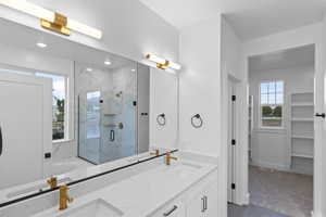Full bath with a marble finish shower, double vanity, a garden tub, and a walk in closet