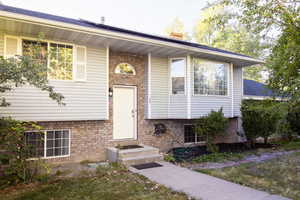 View of front of home with brick siding and a chimney