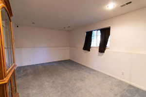 Empty room featuring carpet flooring and baseboards