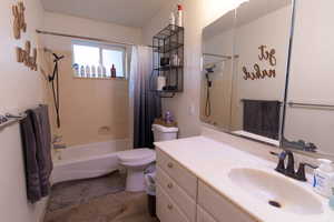 Bathroom featuring shower / bathtub combination with curtain, vanity, and light wood-style floors