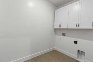 Washroom with hookup for a washing machine, cabinet space, and electric dryer hookup