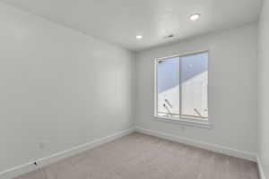 Carpeted empty room featuring baseboards and recessed lighting