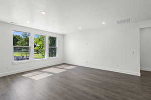 Unfurnished room with dark wood-style floors and recessed lighting