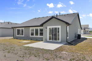 Back of property featuring a patio, a shingled roof, and stucco siding
