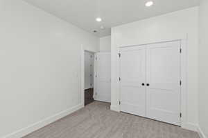 Unfurnished bedroom with carpet flooring, recessed lighting, and a closet