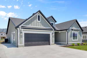 View of front facade featuring board and batten siding, a shingled roof, and concrete driveway