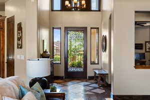 Foyer with inlaid floor details and a chandelier