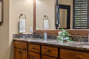 Bathroom featuring tasteful backsplash and vanity