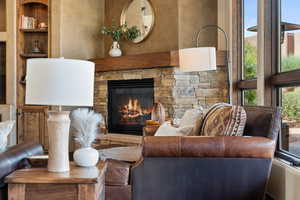 Living room with a stone fireplace and plenty of natural light