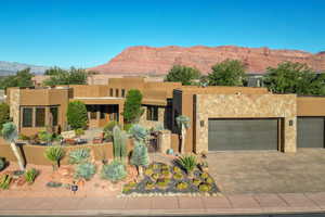 View of front facade with a mountain view, stucco siding, decorative driveway, a patio area, and a fenced front yard