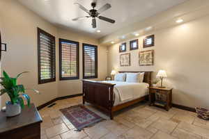 Bedroom featuring stone tile floors, ceiling fan, and recessed lighting