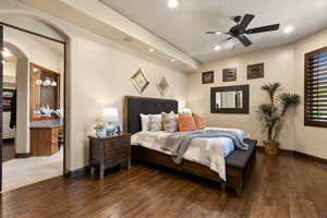 Bedroom with wood-type flooring, a ceiling fan, recessed lighting, connected bathroom, and arched walkways