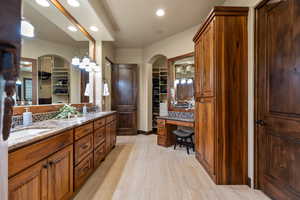 Full bath featuring recessed lighting, double vanity, decorative backsplash, and a walk in closet