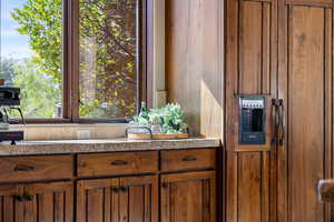 Kitchen featuring brown cabinets and light stone counters