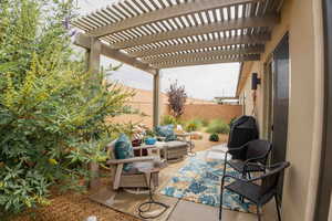 Fenced backyard with a patio, a pergola, and a grill
