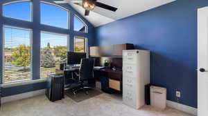 Bedroom being used as an Office with light colored carpet, a ceiling fan, and high vaulted ceiling