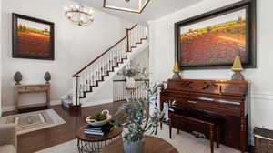 Sitting room with crown molding, wood finished floors, a chandelier, and stairs- Could also be used as formal dining room, baby grand piano room or office.
