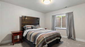 Bedroom with baseboards and light carpet