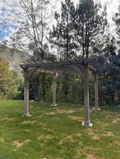 View of grassy yard featuring a pergola