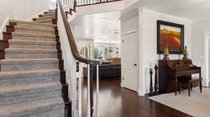 Staircase with wood finished floors, crown molding, and a textured ceiling