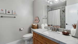 Full bathroom en-suite off of upstairs bedroom featuring vanity, a shower with curtain, and tile patterned flooring