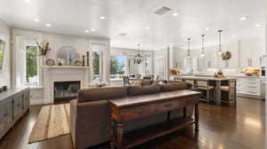 Living room featuring recessed lighting, fireplace, dark wood-type flooring, and a textured ceiling