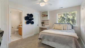 Bedroom with light carpet, a ceiling fan, light tile patterned floors, and connected bathroom