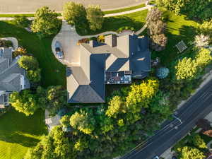 Aerial view of property and surrounding area featuring large grassy side yard, private wooded oasis in backyard and ample parking in driveway.