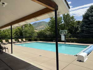 Community pool with a patio and a mountain view