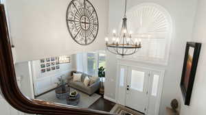 Entryway featuring a chandelier, wood finished floors, and a towering ceiling