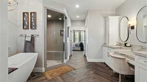 Ensuite bathroom with vanity, a freestanding bath, a stall shower with steam option, separate toilet room and recessed lighting